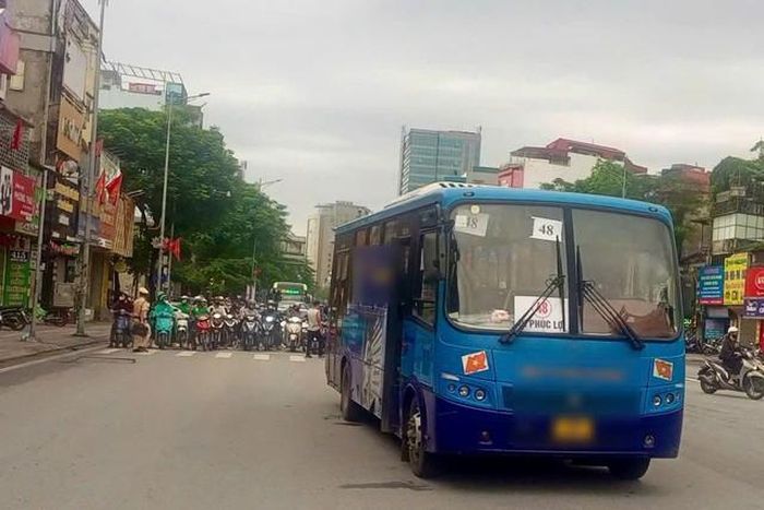 Lực lượng chức năng và người dân phối hợp xử lý hiện trường vụ va chạm giữa xe buýt và xe máy sáng 4/5. Ảnh: Công an cung cấp